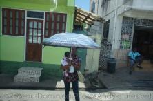 Woman holds an umbrella and her baby in Roseau Dominica.jpg